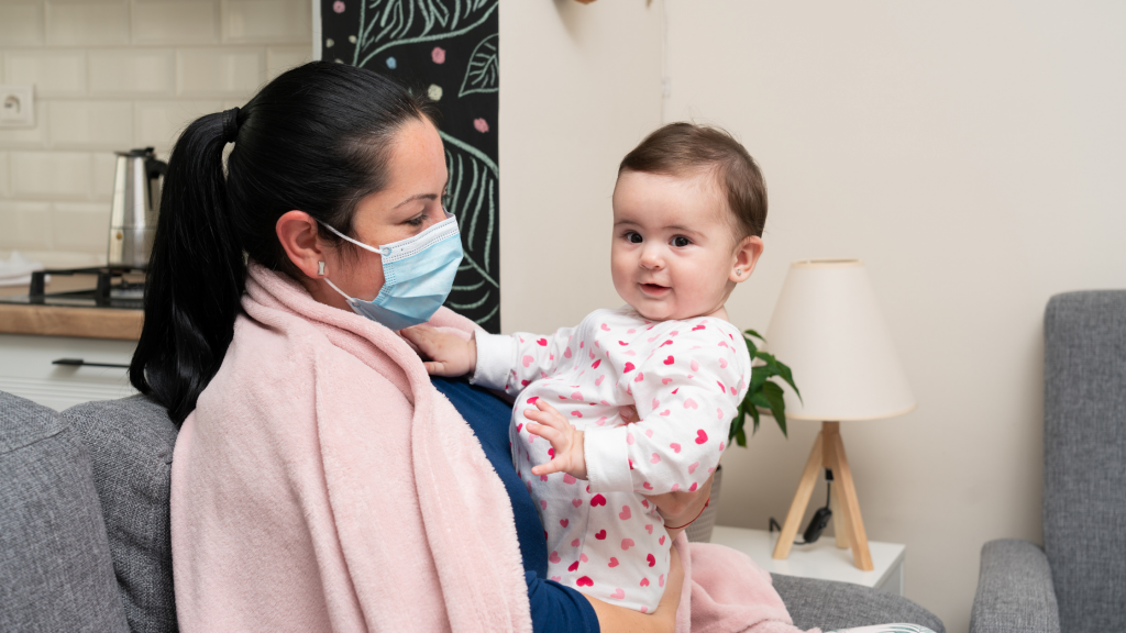 Woman wearing mask, holding baby, Newsletter image