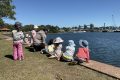 Children sitting on the edge of the harbour learning about Sydney Harbour